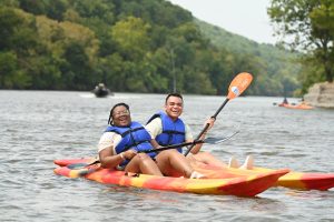 a couple of people riding on top of a kayak