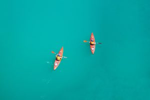 two person kayaking on open body of water