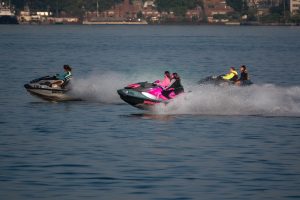 2 people riding on red and white personal watercraft