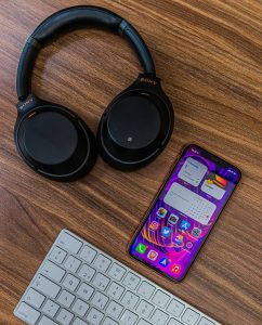 purple and black sony headphones beside purple and black iphone case