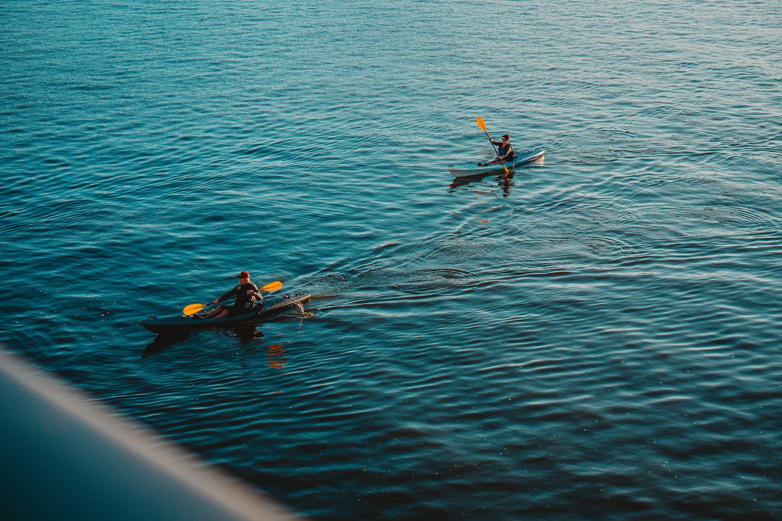 2 person riding on kayak on body of water during daytime